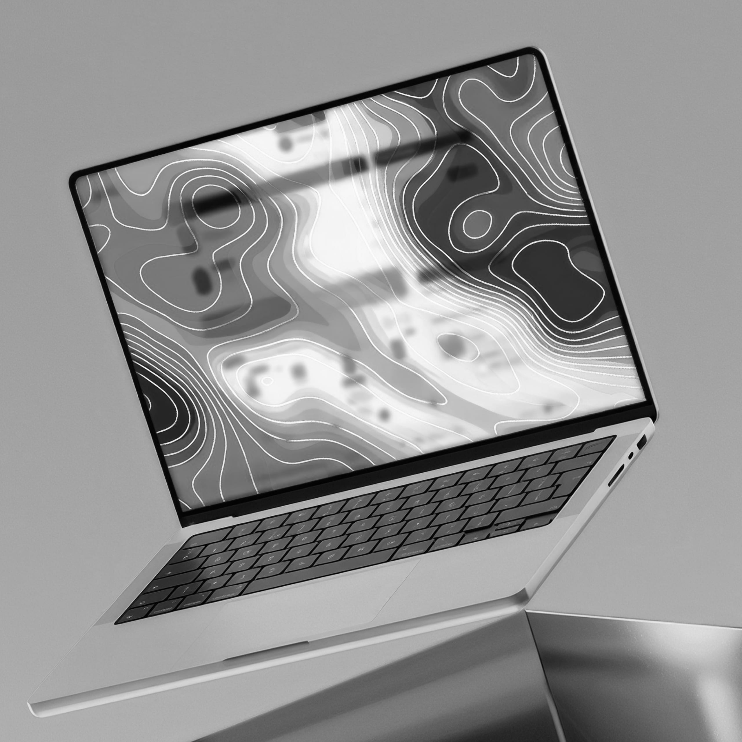 Open laptop showing a topographic heatmap on the screen.